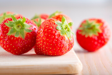 Ripe strawberries on wooden board