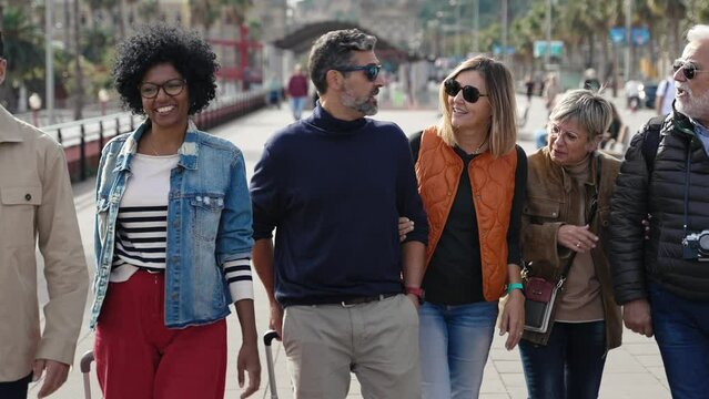 Group of tourist friends with suitcases walking in the city going to hotel or airport 