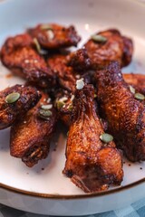 Buffalo wings sprinkled with nuts on a checkered tablecloth