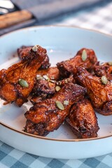 Buffalo wings sprinkled with nuts on a checkered tablecloth