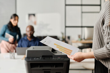Unrecognizable Woman Printing Documents In Modern Office
