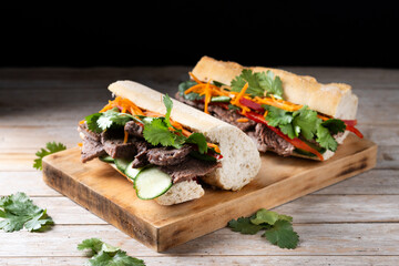 Vietnamese banh mi sandwich on wooden table. 
