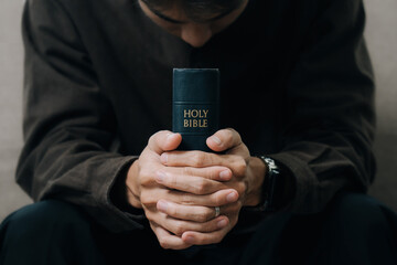 Christian man hands holding the holy bible to pray and worship God in the sunday...