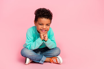 Full length photo of adorable little boy sit floor look cheerful camera dressed stylish cyan...