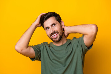 Photo of attractive dreamy man wear khaki t-shirt hands head looking empty space isolated yellow...