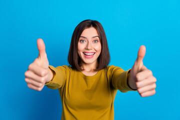 Naklejki  Photo of adorable confident lady dressed shirt showing two thumbs up isolated blue color background