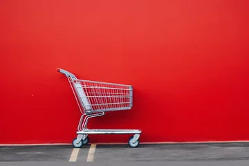 Fotobehang a shopping cart against a red wall © Elena