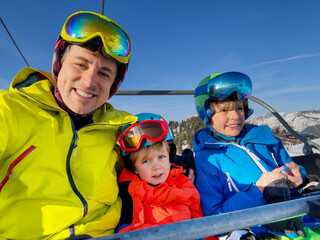Family enjoys ski lift ride in the mountains make funny selfies - 773066117