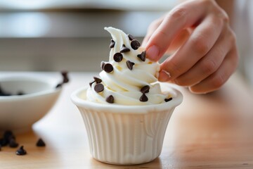 individual garnishing soft serve with chocolate chips