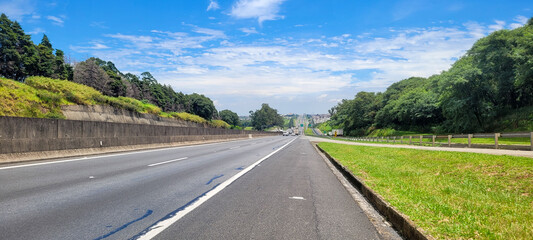 paved road with cars passing by on a sunny day in campinas São Paulo