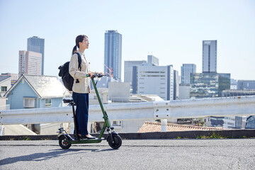 電動キックボードで移動をする日本人女性