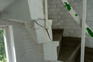 Crack in white spiral concrete stairs