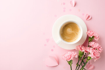 Mother's Day tranquility: A cup of coffee amidst pastel pink carnations and paper hearts, captured...