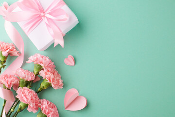 Elegant Mother's Day Wishes: Top view of carnations, paper heart-shaped, gift box on a turquoise...