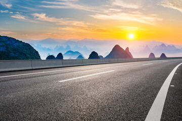 Asphalt highway road and green mountain with sky clouds natural landscape at sunrise - obrazy, fototapety, plakaty