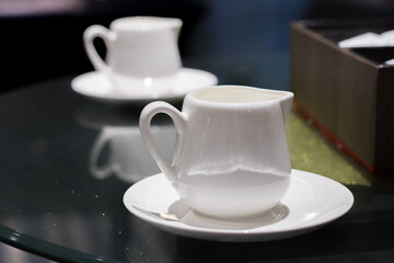 Cup of pouring cream on the table in the cafe
