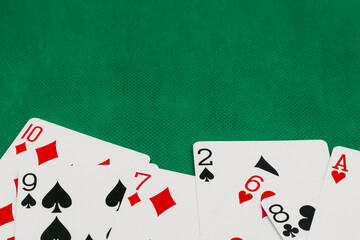 A pile of Poker playing card, playing cards on green background.;