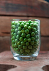 Pean green in bottle glass on wooden background