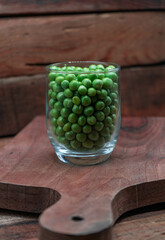 Pean green in bottle glass on wooden background