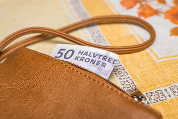 Women's purse with a 50 Danish kroner banknote sticking out, Financial concept, Denmark money, home budget, Cash payment in Scandinavia