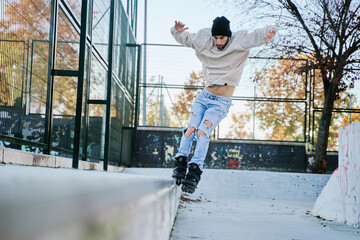 young inline skater in a skatepark doing tricks, grinded out of a kerb.
