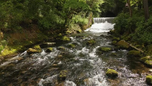 Drone flies above beautiful clear stream of water