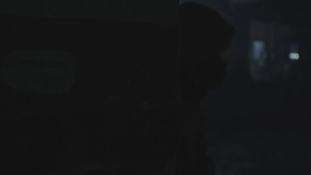 A soldier in a mask peeks quickly around the corner