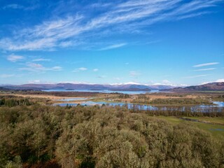 a view of the countryside from a hill with trees and a river