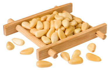 Roasted pine nuts in the wooden plate, isolated on the white background.