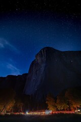 a mountain and stars in the sky with cars parked at night