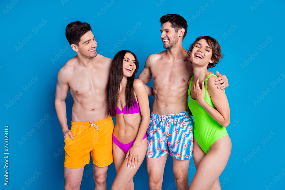 Poster photo of cheerful funky fellows company wear swimsuits cuddling laughing isolated blue color backgro