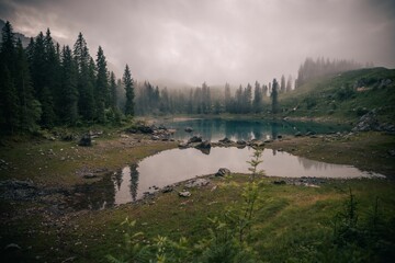 Fototapeta premium Stunning landscape of a tranquil lake surrounded by majestic mountains and trees