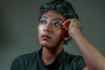 A woman with black hair and red lipstick is looking at the camera