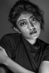 A woman with black hair and a black shirt is posing for a photo