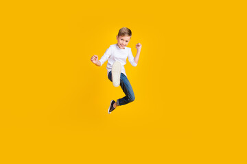 Fototapeta na wymiar Full length photo of positive strong kid dressed white shirt jumping enjoying karate empty space isolated yellow color background