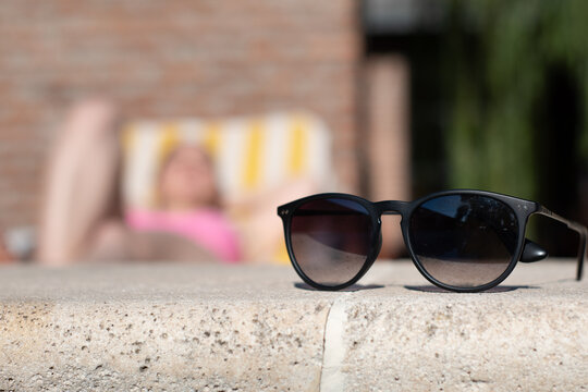 Fotografía conceptual de lentes de sol en piscina, representando el verano, las vacaciones y el descanso