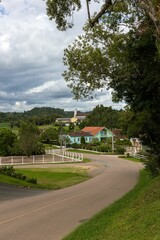 Rural road winding through a tranquil countryside community, surrounded by lush green fields