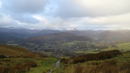 a view of a small village in a big country with mountains in Windermere