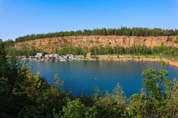 Closeup of a beautiful lush green field and tranquil water under the blue sky in Jaworzno