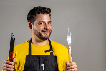 Hombre cocinero feliz sosteniendo sus utensillos de cocina