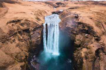 Aerial drone view of Majestic powerful Skogafoss waterfall flowing from cliff among brown mountain in autumn at Southern of Iceland - 773154908