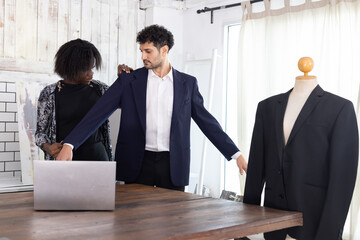 Female tailor fitting businessman for suit in tailor shop