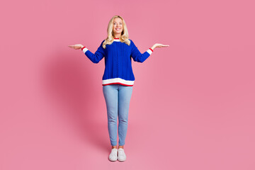 Full size photo of pretty lady arms hold show empty space wear blue sweater isolated on pink color...