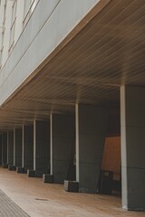 man walking down sidewalk near concrete building in city area with brick walkway and windows