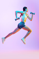 Fototapeta na wymiar Dynamic portrait of young woman running with dumbbells in motion in neon light against gradient studio background. Concept of sport and recreation, movement, self care, action, energy. Ad