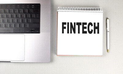 FINTECH text on notebook with laptop and pen