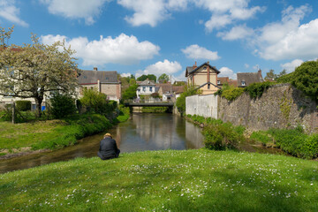 Homme assis contemplant une rivière qui coule dans la ville