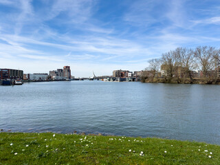 Obraz premium Picturesque vista unfolds over the river, capturing the Prins Clausbrug bridge and the burgeoning housing development of Stadswerven in Dordrecht.