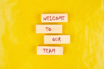 Concept words Welcome to our team on wooden blocks on a yellow background