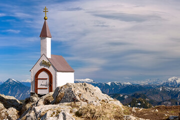 Eine kleine Kapelle steht auf dem Hochgern Gipfel unter einem klaren blauen Himmel in den Chiemgauer Bergen in Bayern Deutschland